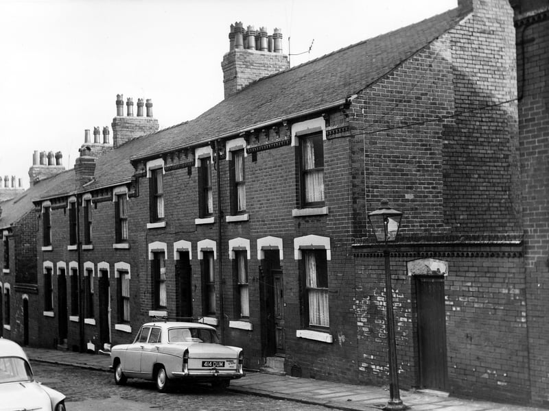 This early 1970s photo shows a row of back-to-back terraced houses on Winchester Terrace flanked by yards housing shared outside toilets. A car, reg: 414 DUM is parked outside number 23.