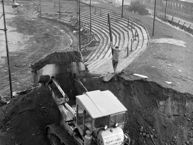 A mechanical digger cuts through the old terracing at Meadowbank as construction begins on the new Commonwealth Games stadium in Edinburgh, January 1968.