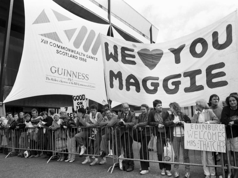 A pro-Thatcher crowd with a 'WE LOVE YOU MAGGIE' banner waits to welcome Prime Minister Margaret Thatcher to the Edinburgh Commonwealth Games 1986, held at Meadowbank Stadium.