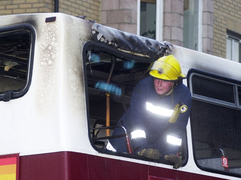 A fireman from Marionville station (Red Watch) inspects a Lothian Region transport double-decker bus which was set alight on Marionville Road near Meadowbank, on August 13, 2002.