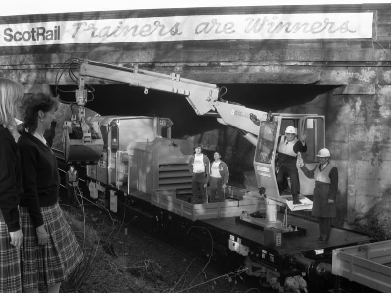 Commonwealth Games hostesses Gina MacRae and Linda Cronan greet former Lord Provost Kenneth Borthwick, chairman of the Commonwealth Games Organising Committee, as he steps down from a mechanical digger in January, 1986, after cutting the first sod at the new Meadowbank Station to be used for a shuttle service during the Games.