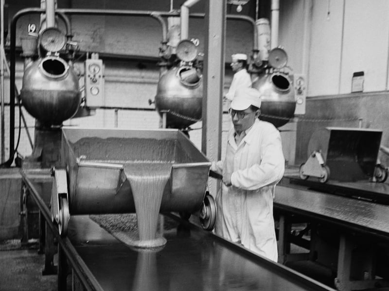 A worker pours molten toffee onto an assembly line at the Sharp's Toffee factory, Maidstone, Kent, in June 1958