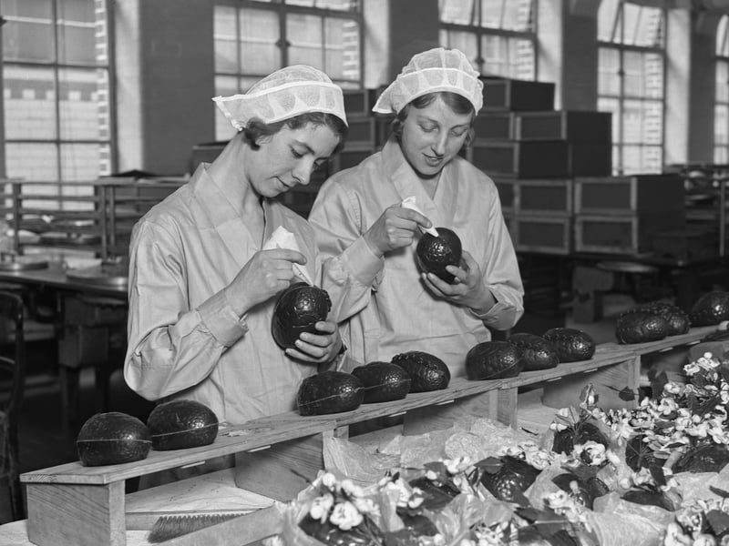 Two women at the Cadbury's chocolate factory in Bournville join together chocolate Easter egg halves in February 1932
