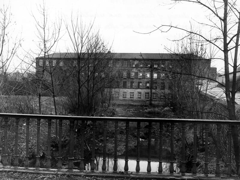 Armley Mills from the east pictured circa 1970s. This photo was taken prior to the clearing of the head race and rebuilding of the left hand retaining wall but after removal of a concrete walkway. At this time the mills were owned by Leeds City Council and were later reopened in 1982 as Leeds Industrial Museum