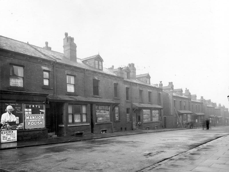 Row of derelict terraced houses on Glenthorpe Terrace. Shop to left of picture with advertising posters for Fry's, Mansion Polish, Lyon's Tea and poster for Scala Theatre. Pictured in November 1938.