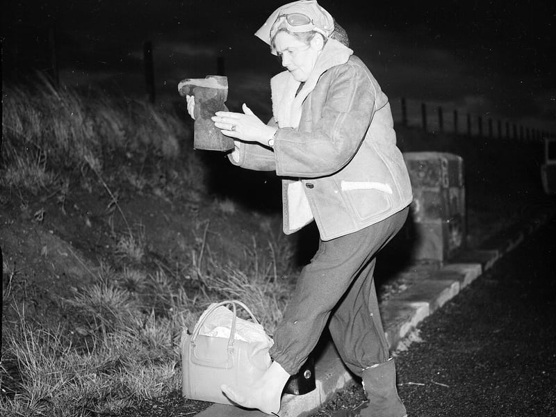 Dr Barbara Moore shakes a stone from her shoe on Saughton Hill on her march from Edinburgh to London in December 1959.
