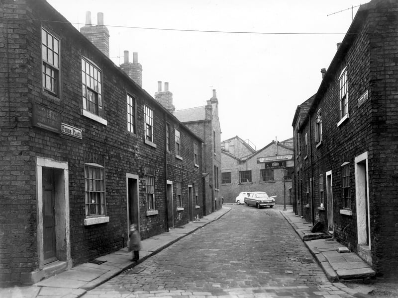 Eyres Place in November 1957. On the left are numbers 1 to 7 and on the right are numbers 2 to 8. In the distance is Winker Green and the Automobile Glass Co. Ltd, a division of the Motor Distributors Garage on Stanningley Road.