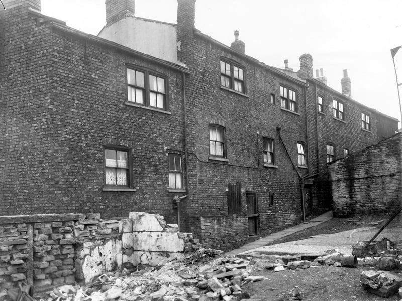Buildings on Winker Green at the rear of blind back terraced houses numbers 60 to 66 Theaker Lane. Building debris in the foreground suggests out buildings that have been demolished. Pictured in November 1957.