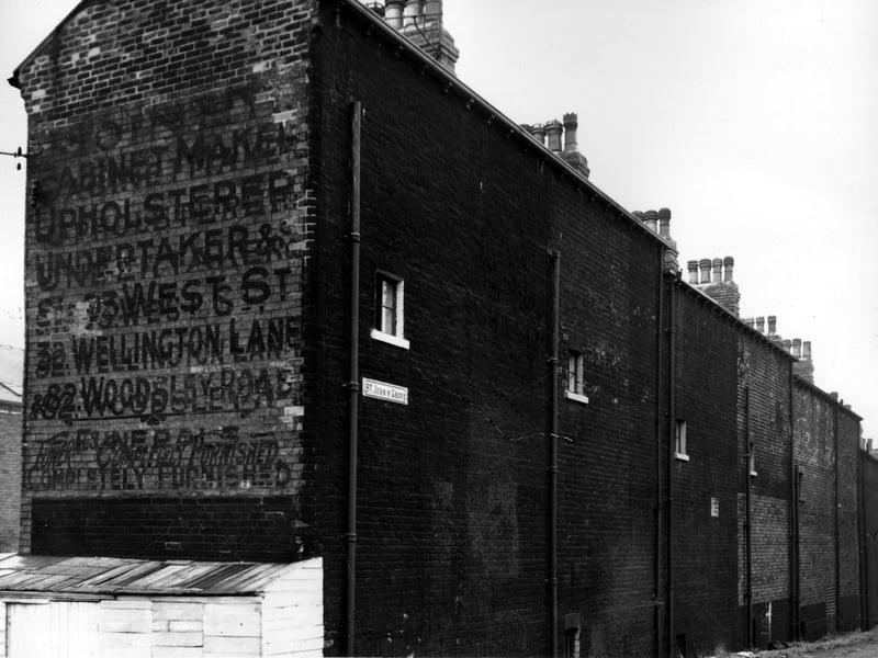 This is the gable end wall of Woodsley View, there is a faded wall sign advertising a joinery and funeral directors business. There seem to be three locations, Wellington Lane, Woodsley Road and 91/93 West Street. A joiner Charles Mountain operated from the West Street location. St Johns Grove ran between the back of Woodsley View and the gardens of houses on Moorland Avenue. Pictured in November 1963.