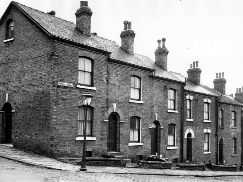 A view from Osborne View to Victoria Mount. Number 20 is on the left with a door onto Osborne View. There is a discrepancy between the numbering on maps, which show this as 20 and the number on the property which is 21. Moving right, 18 Victoria Mount, then 16, 14 and 12. Pictured in November 1963.