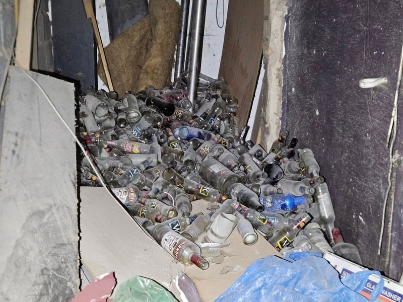 A pile of dusty bottles remain at the derelict site.