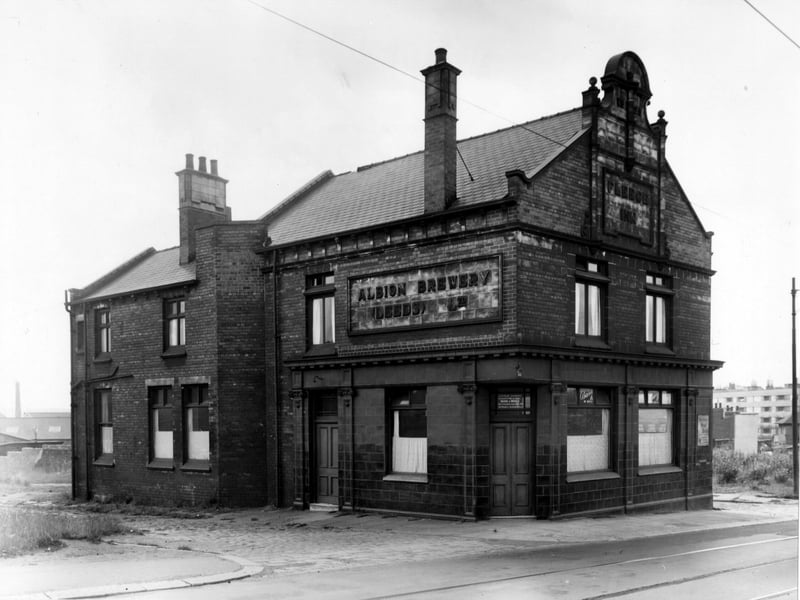 This photo shows the Fleece Inn on York Road. The Inn is an Albion Brewery, and the licensee is Gertrude Sammons. A sign for 'Mercer's Meat Stout' is visible to the right. Tramlines and cables visible. Pictured in September 1955.