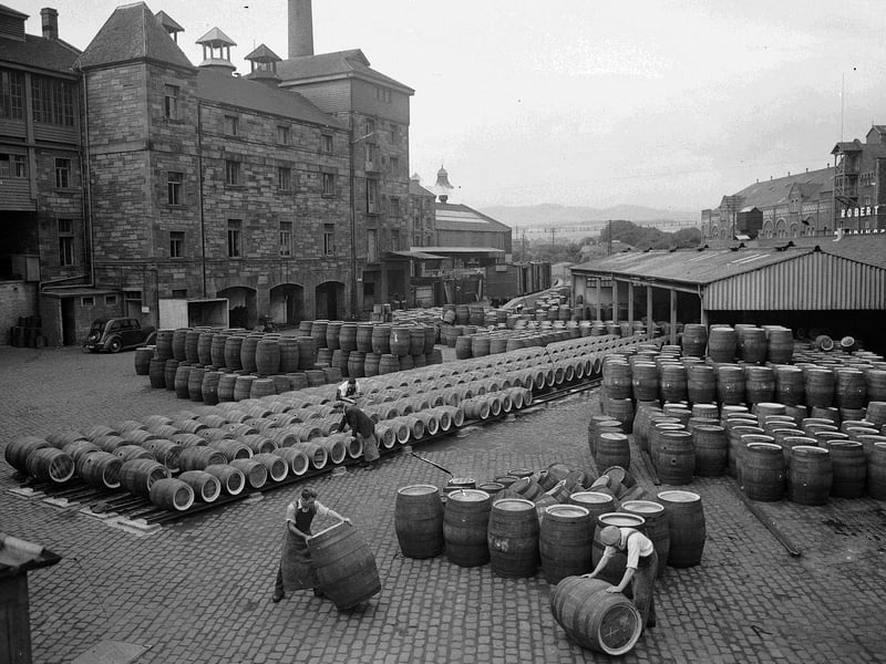 Workmen rolling barrels at Drybrough's Brewery at Craigmillar in August 1955.