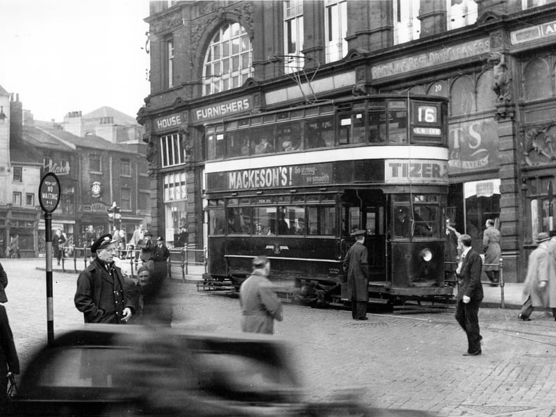 Tram No 6 on Route 16 to the New Inn. The tram is on Kirkgate at the side of Kirkgate Market and the camera is looking in the direction of Vicar Lane. Adverts for Mackeson's Stout and Tizer can be seen on the side and front of the tram. Pictured in October 1954.
