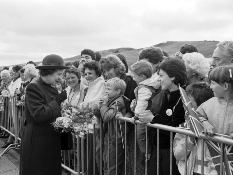 Queen Elizabeth II sniffs some flowers given to her as she officially opens the new ethylene plant at Mossmorran, Fife, in June 1986