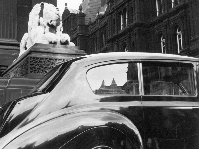 An Austin Vanden Plas Princess parked outside Leeds Town Hall, background, left. One of the four, white Portland stone lions, sculpted by William Day Keyworth Junior, can be seen.