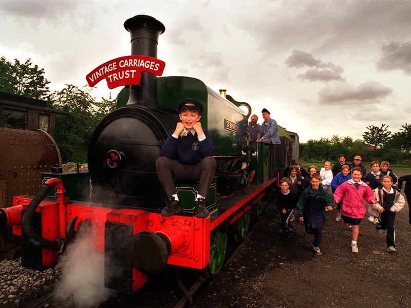 Pupil Robert Hall, 11, sits on the front of one of the steam engines while some of his classmates from Middleton St Mary's C of E Primary School dash to have a look. Pictured in June 1997.