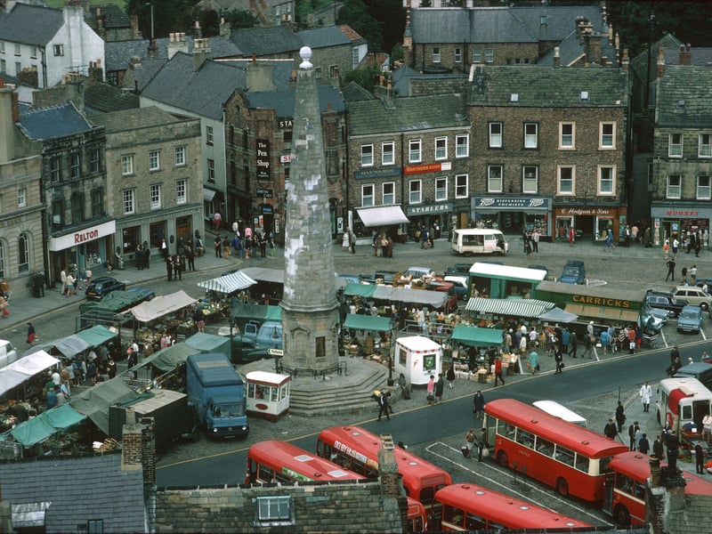 The shops around Richmond market-place, Yorkshire, pictured during the 1970s, with the 18th-century obelisk at the centre
