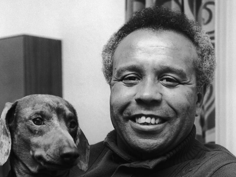 English footballer and stand-up comedian Charlie Williams relaxes at his Yorkshire home with his dog Max in November 1973