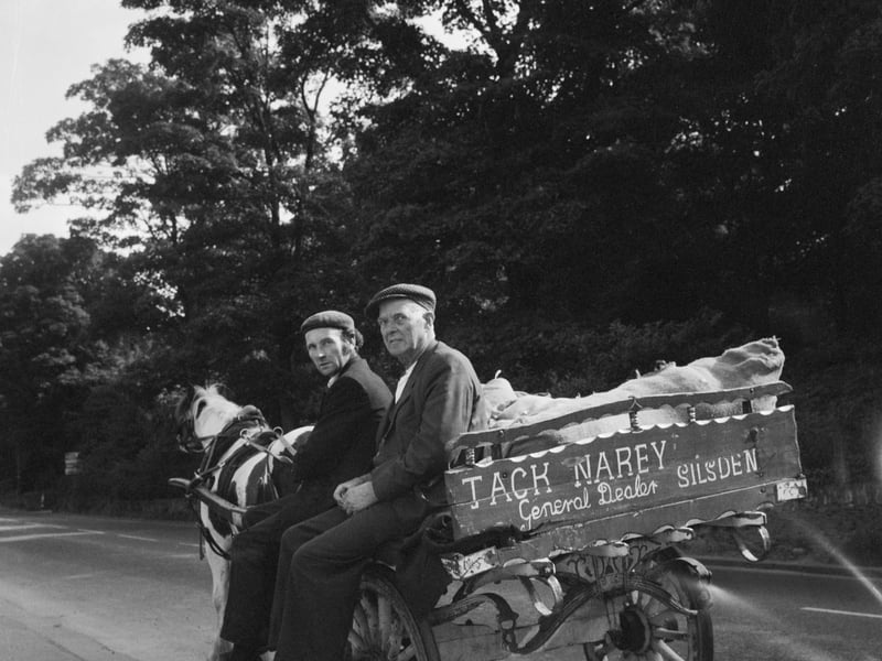 Two men seated on a horse and cart on a road in West Yorkshire during the late 60s or early 70s. The cart is marked with the name 'Jack Narey, General Dealer, Silsden'.