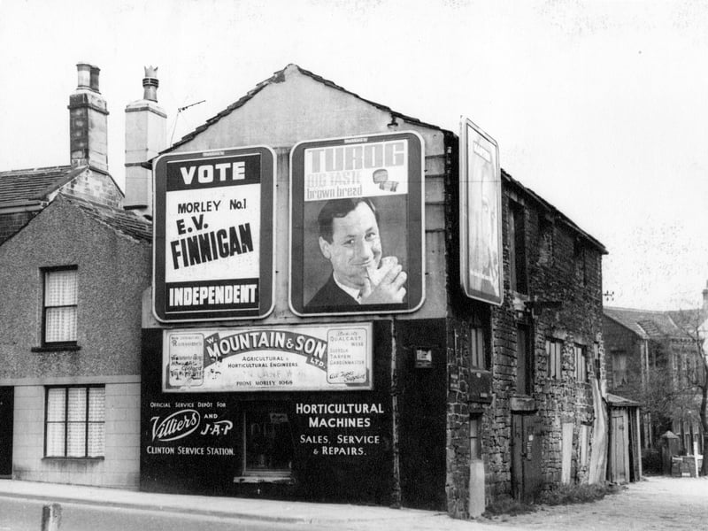 6a Church Street, a three storey terraced property, pictured in April 1967. On the gable end are a number of advertising signs including, Turog big taste brown bread, W. Mountain and Son Ltd, Agricultural Horticultural Engineers, and an election poster, Vote Morley number 1 E.V. Finnigan, Independent'.
