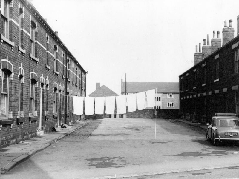 Commercial Square off Commercial Street. Terraced houses with a line of washing across between the houses. A mini is parked to the right of the Square. Pictured in April 1967.