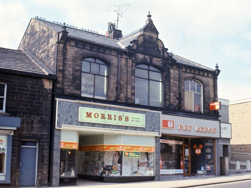 Two shops (Morris Wallpaper and Paints and Red Arrow TV Rentals) pictured in May 1967 at the southern end of Queen Street, which occupy what was originally one large building dated 1890 and called The Benefactory. This was built by an influential draper named Frederick Tesseyman who was responsible in 1879 for organising Tuesday as half-day closing in Morley.