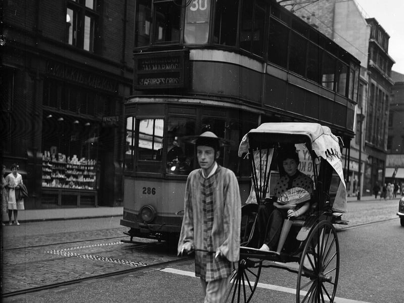 For the Ferry to Hong Kong film premiere at the Odeon Cinema, Glasgow, a rickshaw is seen making its way along Renfield Street, beside the number 30 tram, in July 1959