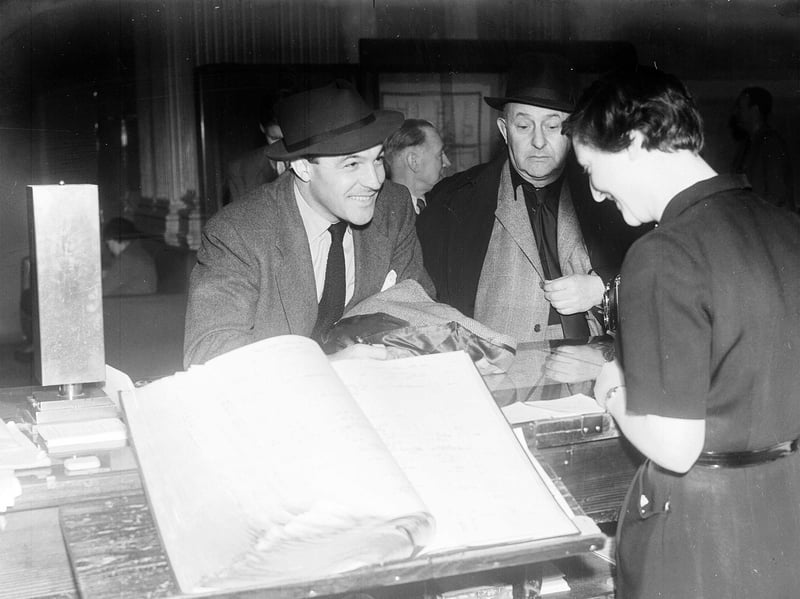 Actor Gene Kelly, with film producer Arthur Freed, checking in at the Caledonian Hotel, Edinburgh, in April 1953