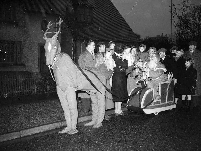 Santa and a reindeer distributing presents in Muirhouse in December 1953.