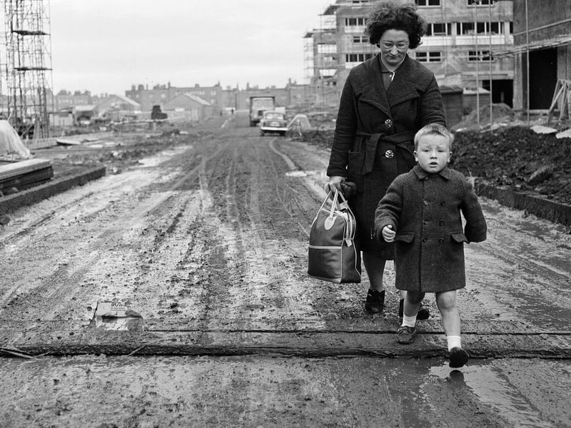 Norma Dickson and her son walk through a muddy Muirhouse street in November 1964.