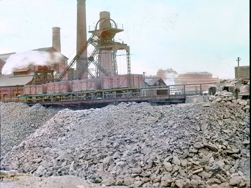 A tinted glass lantern slide of Middleton Colliery from 1909. In the centre of the image is a slag heap, above which is a pit-head winding gear.