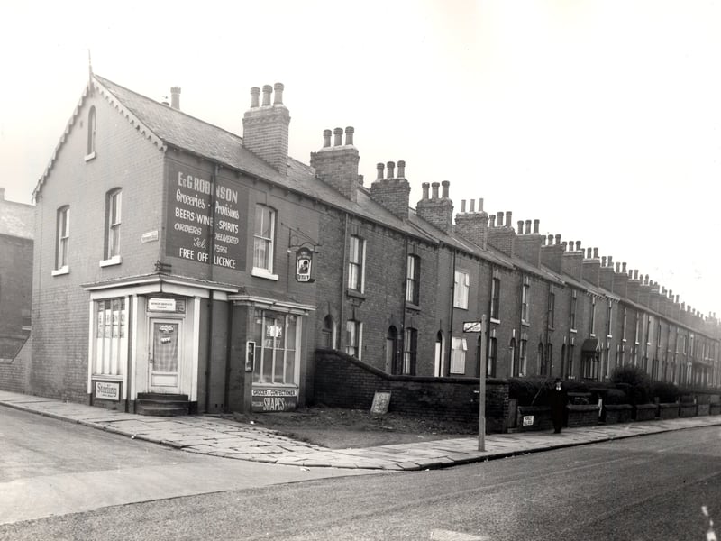 Long view of through terraced properties in Hunslet Hall Road. On the corner, at 2 Northcote Road is E. & G. Robinson, an off licence also selling groceries and confectionary. A bus stop is opposite the off licence, almost on the corner with Northcote Road, left. Pictured in November 1965.
