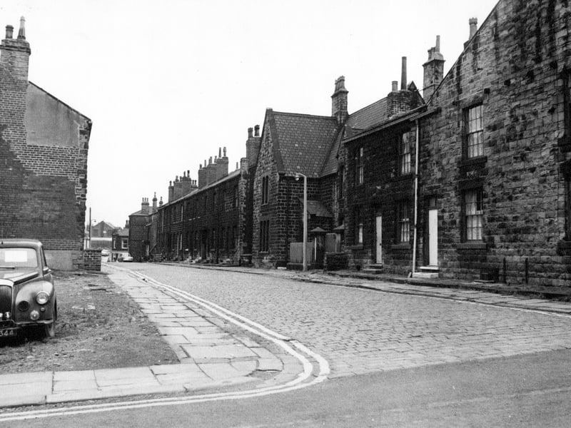Oddfellow Street from the junction with Wesley Street towards Fountain Street in August 1968. A block of terraced houses have been demolished on the left and a car is parked in the waste ground.
