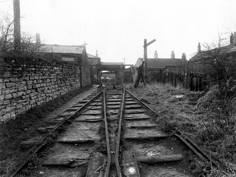 The railway track and winding gear used to draw wagons up the steep incline from Broom Pit to Middleton Town Street at Rope Hill. The backs of cottages on Town Street in the vicinity of Holmsville house can be seen, as can a set of points and a rudimentary signal. Pictured in November 1950.