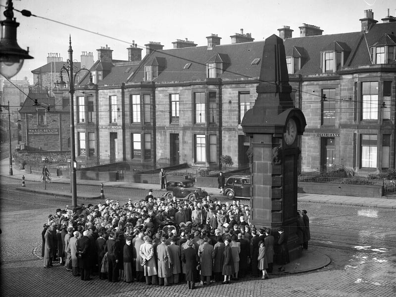 Crowds gather around the Heart of Midlothian War Memorial clock at Haymarket on Remembrance Day 1950 to commemorate the Hearts players who died during World War One.