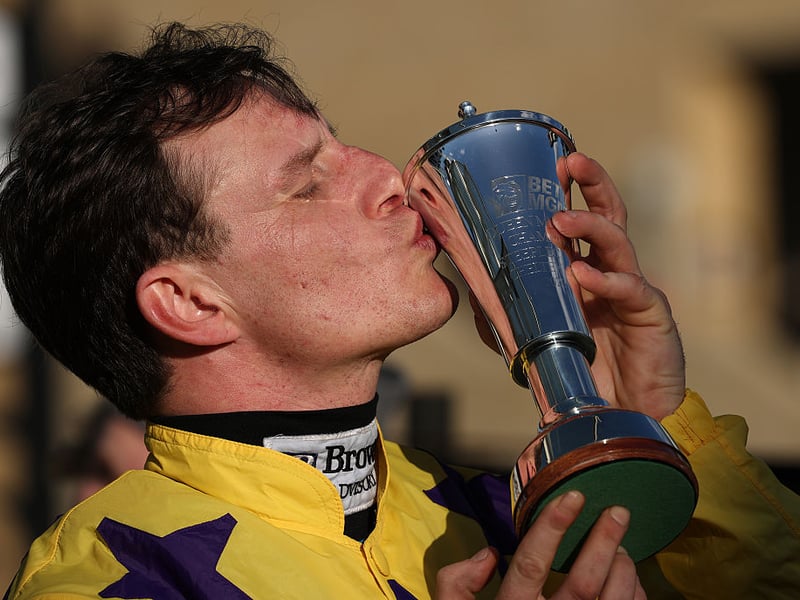 Paul Townend kisses the BetMGM Queen Mother Champion Chase trophy after victory on Il Etait Temps.