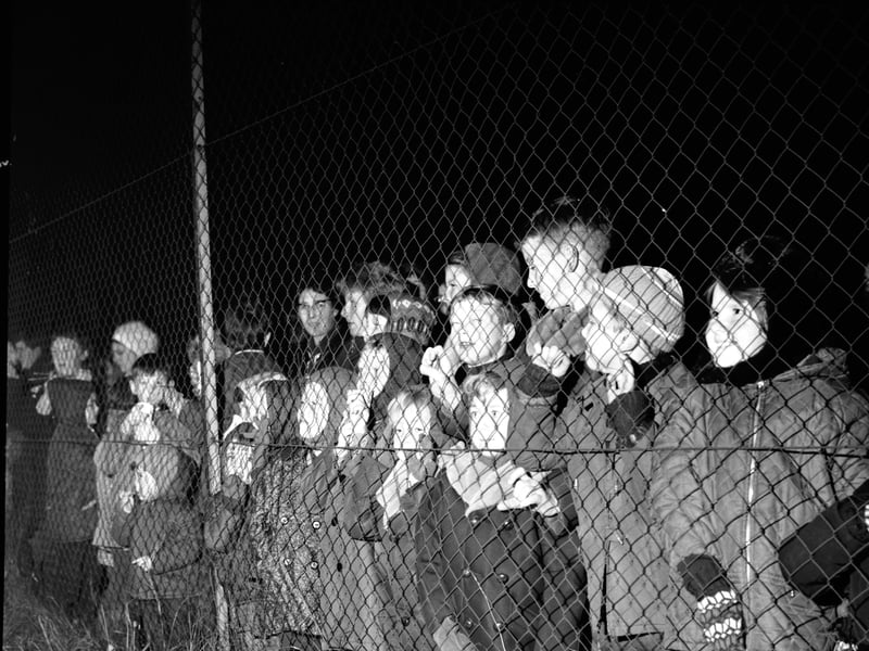 Children are kept safe behind a chain link fence at an organised bonfire and firework show staged at Redford Barracks, Edinburgh, in November 1968