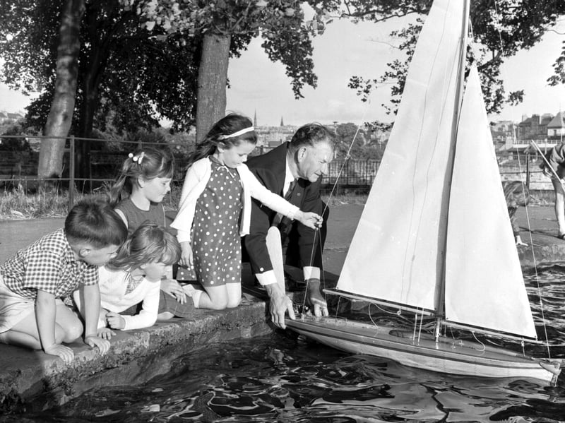Children watch a man with his model sailing boat at Inverleith Pond, Edinburgh, in 1969