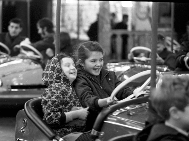 Two little girls enjoy the dodgems, one of the rides at the Waverley Market Carnival, in December 1968
