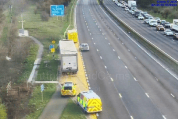 Motorway cameras show police vehicles on the M1 and standing traffic.
