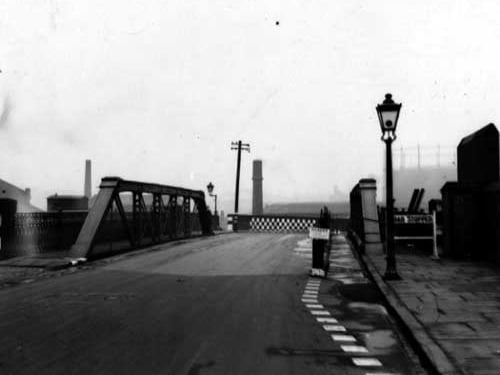The bridge on Viaduct Road over the Leeds Liverpool Canal in March 1945. Repair work is being done to the east side of the footpath as the footplanks are being replaced. Signs saying 'Danger, Please Use Temporary Footpath', and 'Road Stopped', are all visible.
