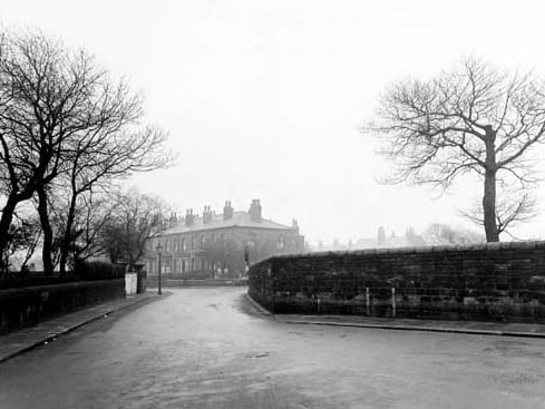 Looking south-east from Church Road, along part of Strawberry Lane towards Hall Lane in December 1947. The road is bordered by stone walls. The houses of Hall Lane are in the distance.