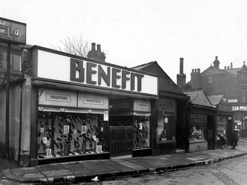 Shops on Stonegate Road in November 1942. They are; number 8, Benefit Footwear Ltd.; number 4, J.Ellis & Co., boot repairs; number 2a, Leeds Drug Co. Ltd.; number 2, Vennard's confectioners and Meanwood Post Office, where two people can be seen looking in the window. A post box is on the corner, with Authorpe Road and Hopkinson's grocers behind.
