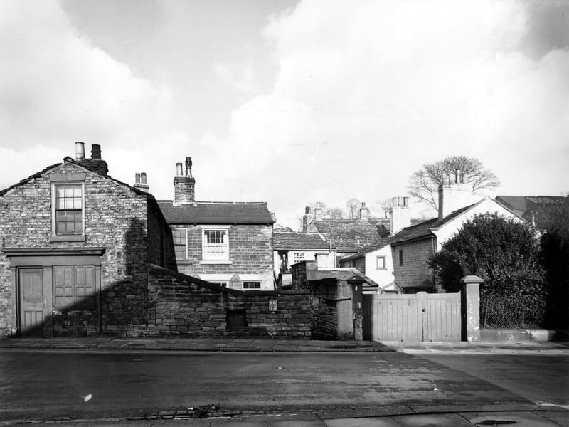 The east end of Potternewton Lane pictured in November 1949. Row of houses with a man standing in a doorway.