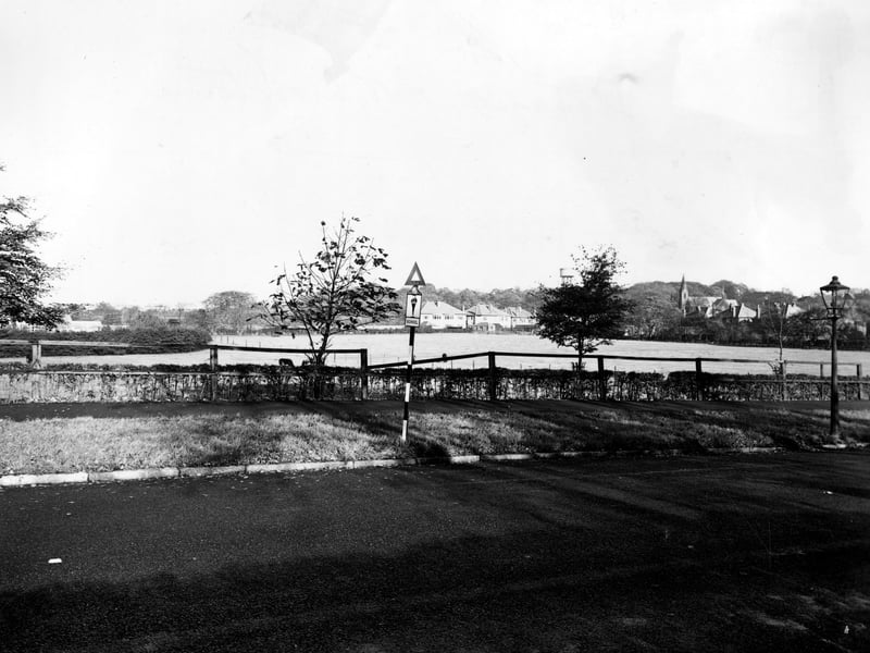 A view from Stonegate Road across fields towards a church and Church Road in November 1949.