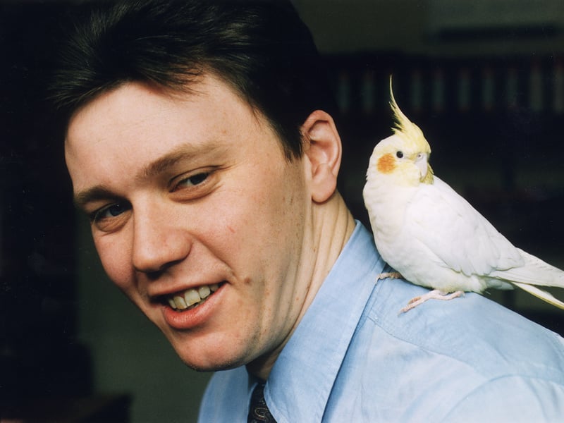 Civilian police worker Ralph Orme with a cockatiel on his shoulder, which he found and took to work with him at Gayfield Square, in 1996
