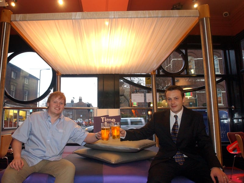 Manager Donal Hartnett, right, and barman Luke William try out the giant four-poster bed at the revamped Bedroom bar, formerly the Saddle, on West Street, Sheffield, in December 2003