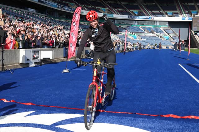Greg James celebrates as he crosses the finish line on the final day of Radio 1's Longest Ride challenge for Comic Relief at Murrayfield Stadium .