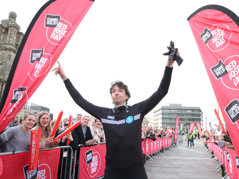 Greg James crosses the finish line on Day 6 of Radio 1's Longest Ride challenge for Comic Relief.